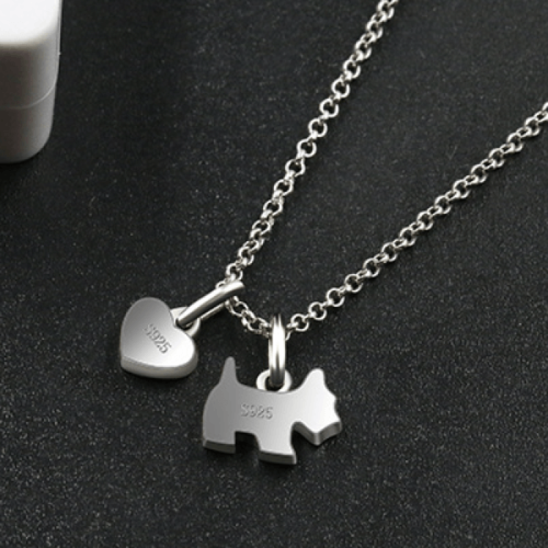 Sterling silver necklace featuring a zircon-studded dog pendant and polished onyx heart charm