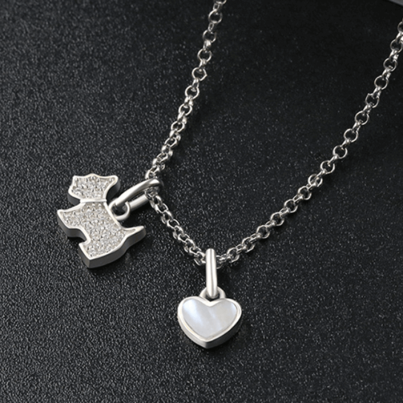 Sterling silver necklace featuring a zircon-studded dog pendant and polished onyx heart charm